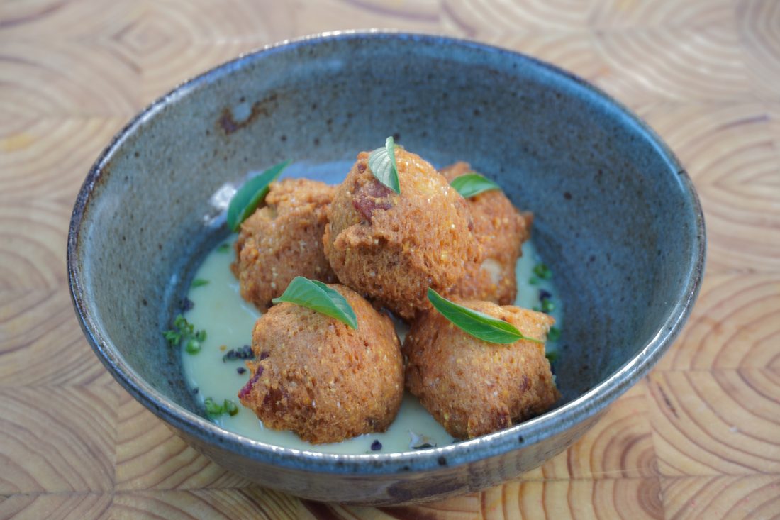 Crispy croquettes with whipped sauce and Thai basil, golden hour light